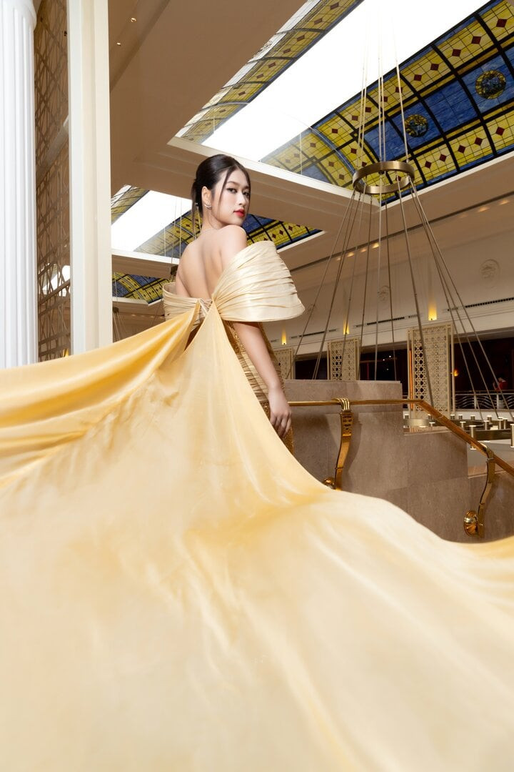 Thiết kế sử dụng chất liệu xuyên thấu mỏng kết hợp tông màu vàng gold đặc trưng của Miss Grand, phía sau có tà dài hàng mét để tăng độ lộng lẫy. Nhà thiết kế cùng đội ngũ mất 400 giờ làm việc để hoàn thiện các công đoạn, trong đó có khâu đính kết những hạt cườm liti tạo họa tiết hoa văn chạy khắp thân váy. Thiết kế sử dụng chất liệu xuyên thấu mỏng kết hợp tông màu vàng gold đặc trưng của Miss Grand, phía sau có tà dài hàng mét để tăng độ lộng lẫy. Nhà thiết kế cùng đội ngũ mất 400 giờ làm việc để hoàn thiện các công đoạn, trong đó có khâu đính kết những hạt cườm liti tạo họa tiết hoa văn chạy khắp thân váy.