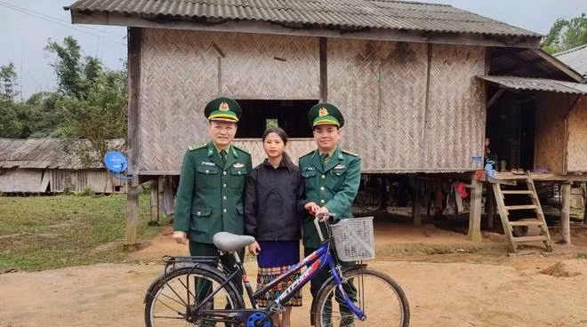 Cô bé Hồ Thị Nghinh (bản La Lay A Sói), "đại sứ" nghĩa tình Việt - Lào, cùng cán bộ biên phòng VN