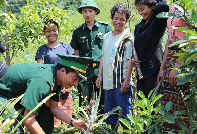 Cán bộ, chiến sĩ Đồn biên phòng cửa khẩu A Đớt hướng dẫn người dân bản Ka Lôi (H.Ka Lùm, Lào) trồng dứa...