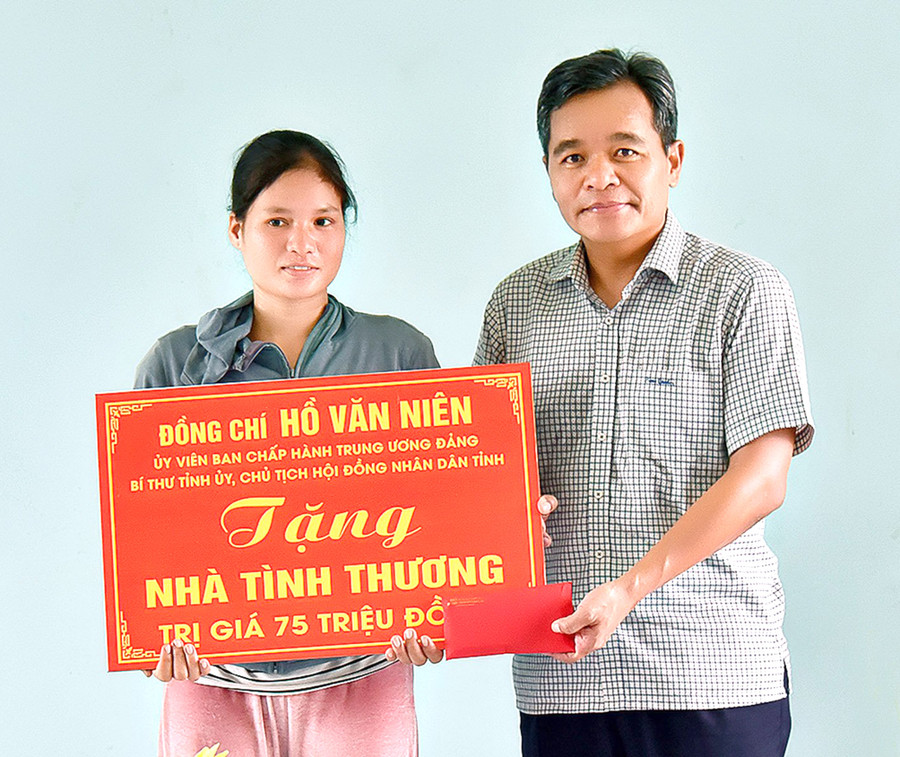 Bí thư Tỉnh ủy, Chủ tịch HĐND tỉnh Hồ Văn Niên trao tặng nhà tình thương cho gia đình chị Đinh Tuin (thôn Voòng Boong, xã Chư Răng). Ảnh: Đức Thụy