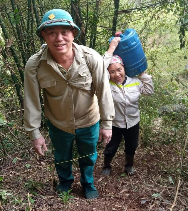 Ông Trần Huấn tham gia gùi cát lên núi cùng bà con