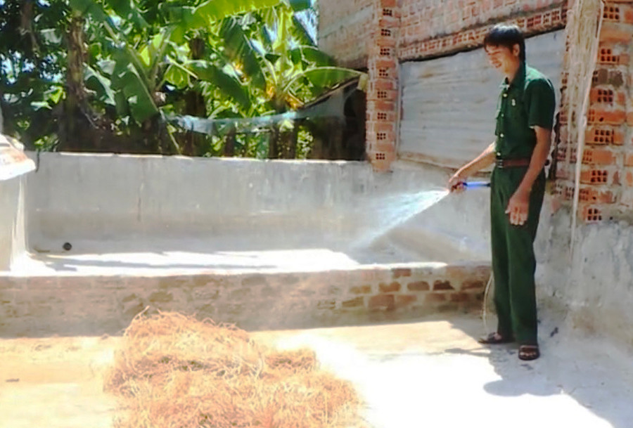 Cựu chiến binh Trịnh Kế Vượn (thôn Plei Gok, xã Ia Piar, huyện Phú Thiện) phun chế phẩm khử khuẩn rơm rạ trước khi ngâm ủ. Ảnh: Vũ Chi