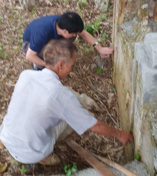 Tiến sĩ Lê Hồng Vệ (áo đen) nghiên cứu các câu đối ở ban thờ tại Lèn Choi