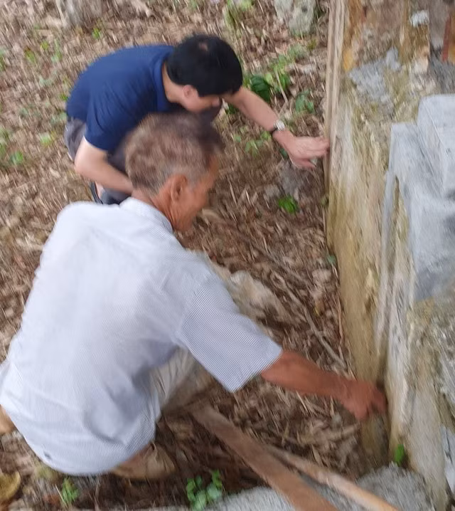 Tiến sĩ Lê Hồng Vệ (áo đen) nghiên cứu các câu đối ở ban thờ tại Lèn Choi