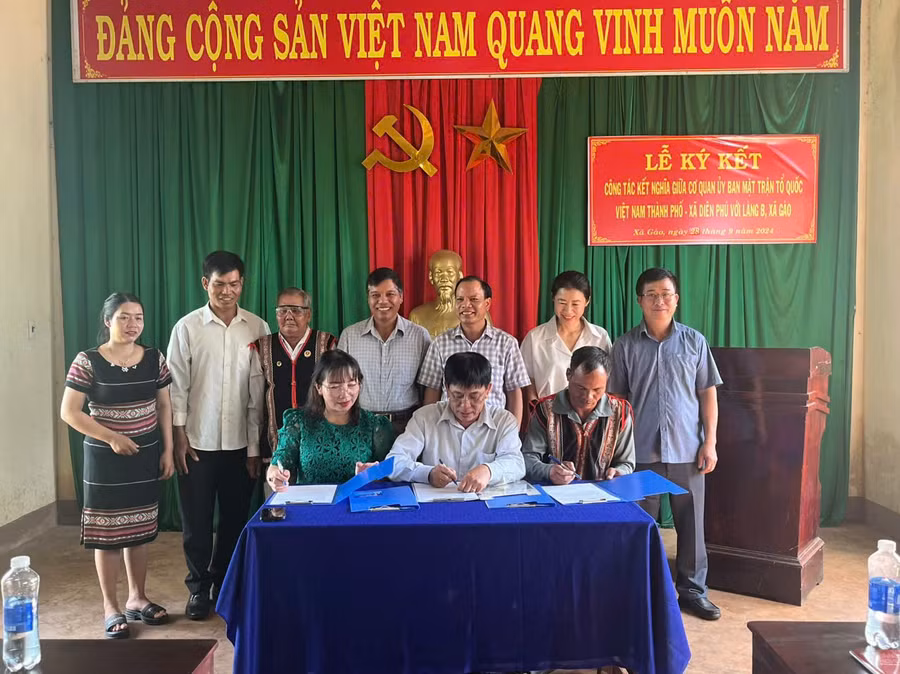 Đại diện Ủy ban MTTQ Việt Nam thành phố, đại diện xã Diên Phú và đại diện làng B đã ký giao ước kết nghĩa. Ảnh: D.T