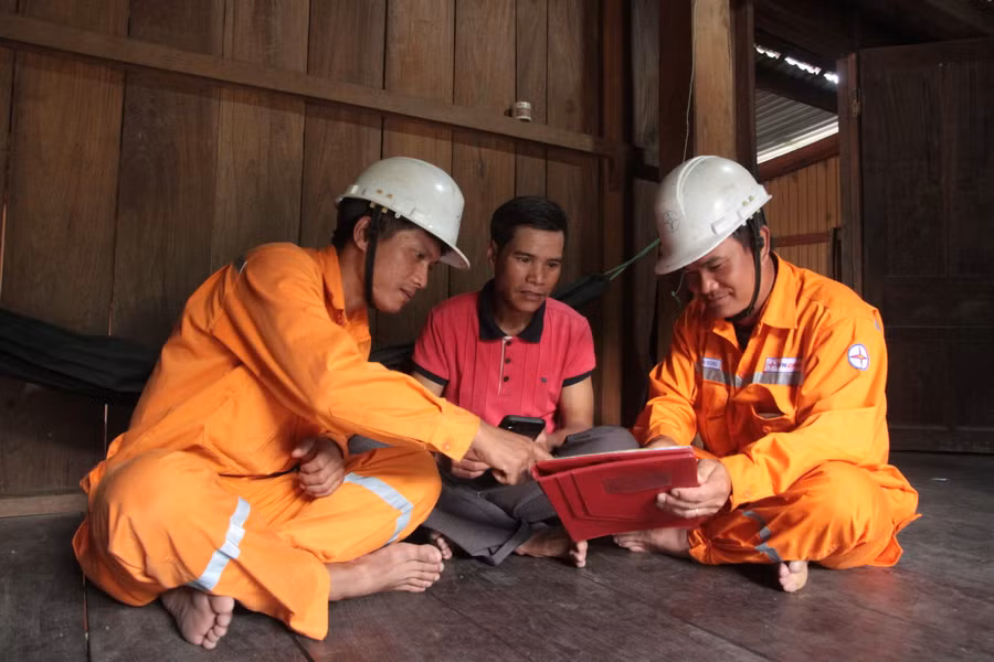 Nhân viên Điện lực Kbang tuyên truyền, hướng dẫn người dân tải ứng dụng theo dõi hóa đơn tiền điện. Ảnh: Hoàng Hoài