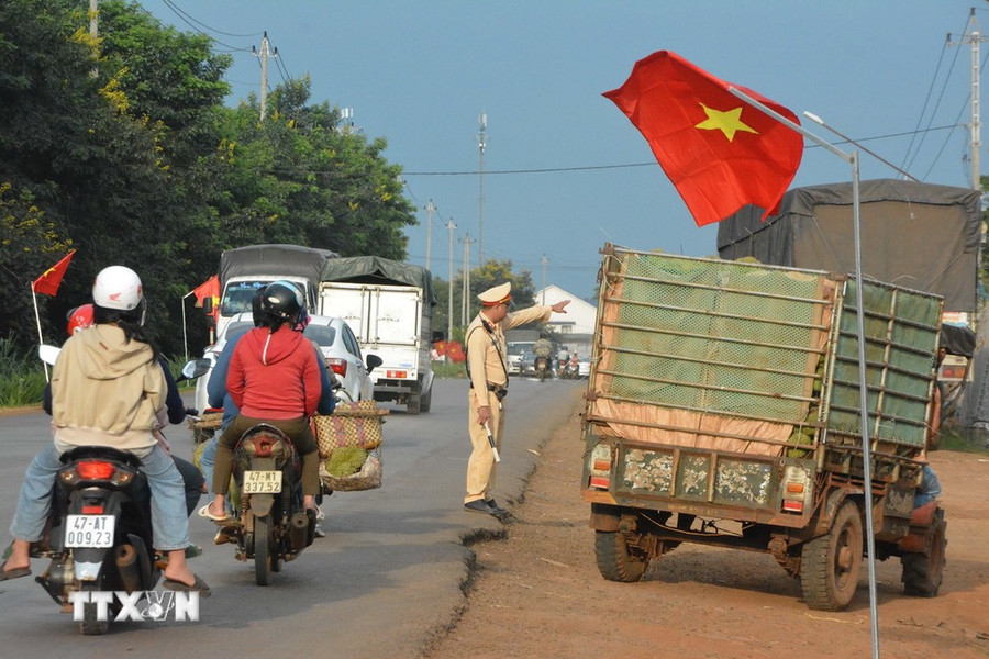 Lực lượng cảnh sát giao thông phân luồng cho xe chở sầu riêng để giảm áp lực lưu thông trên Quốc lộ 26. (Ảnh: Tuấn Anh/TTXVN) Lực lượng cảnh sát giao thông phân luồng cho xe chở sầu riêng để giảm áp lực lưu thông trên Quốc lộ 26. (Ảnh: Tuấn Anh/TTXVN)