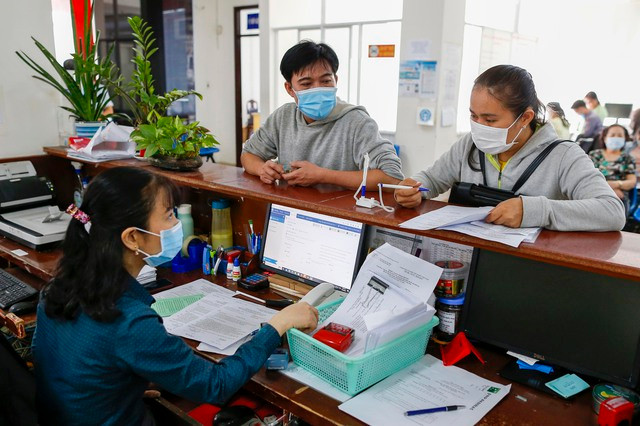 Người dân làm thủ tục tại BHXH TP HCM Ảnh: HOÀNG TRIỀU