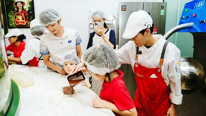 Khách hàng nhí trải nghiệm làm sô-cô-la tại cửa hàng của anh Huy. Khách hàng nhí trải nghiệm làm sô-cô-la tại cửa hàng của anh Huy.