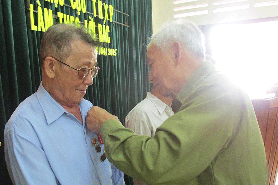  Trao tặng huy hiệu Cựu Thanh niên xung phong làm theo lời Bác. Ảnh: Phan Lài