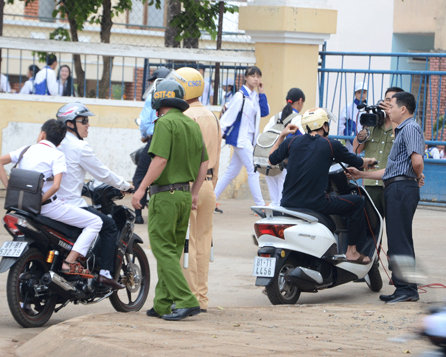 Công an TP. Pleiku nhắc nhở phụ huynh đội mũ bảo hiểm cho con khi đi xe máy. Ảnh: Vĩnh Phúc  Công an TP. Pleiku nhắc nhở phụ huynh đội mũ bảo hiểm cho con khi đi xe máy. Ảnh: Vĩnh Phúc