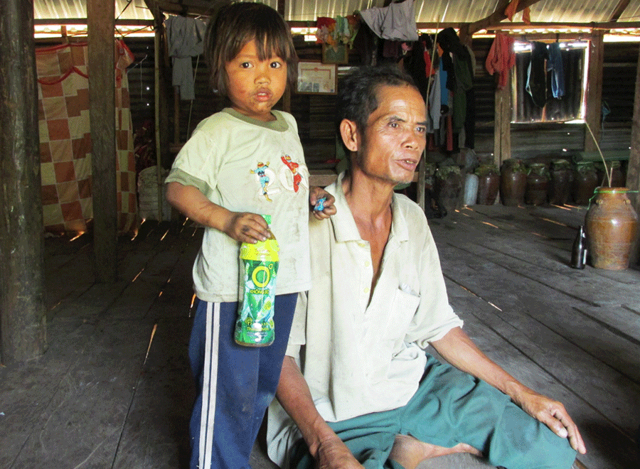  Ông Đinh Binh bên đứa cháu gái út đã mồ côi cả cha lẫn mẹ vì tự tử. Ảnh: Hải Lê