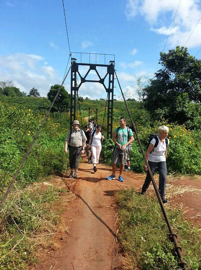 Du khách qua cầu treo để đến làng Đê Ktu. Ảnh: H.A Du khách qua cầu treo để đến làng Đê Ktu. Ảnh: H.A