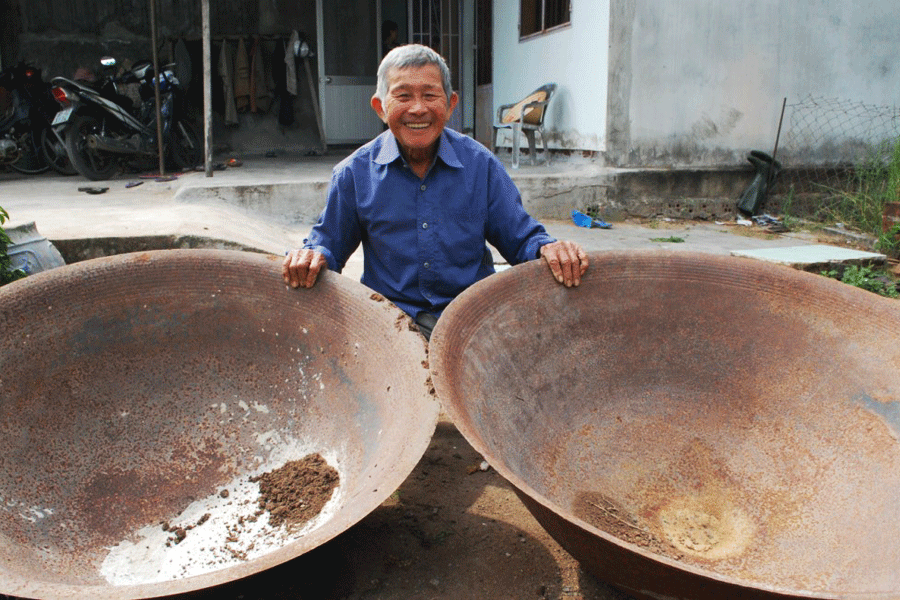 Ông Năm Thao và chiếc chảo gang nấu đường còn sót lại. Ảnh: Nguyễn Tú Ông Năm Thao và chiếc chảo gang nấu đường còn sót lại. Ảnh: Nguyễn Tú