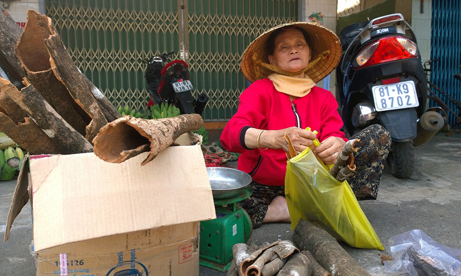 Bà Nữ đang cân quế để bán cho khách