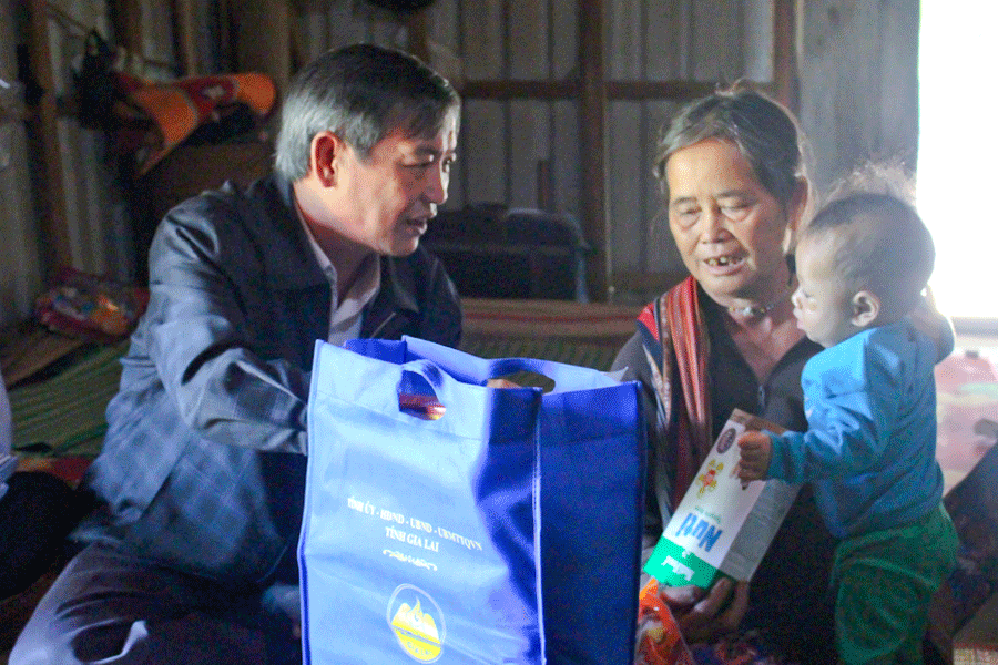 Ân cần hỏi thăm bà Đinh Thị Thươl-thân nhân liệt sĩ tại làng Groi, xã Kông Bờ La. Ảnh: Hồng Thi