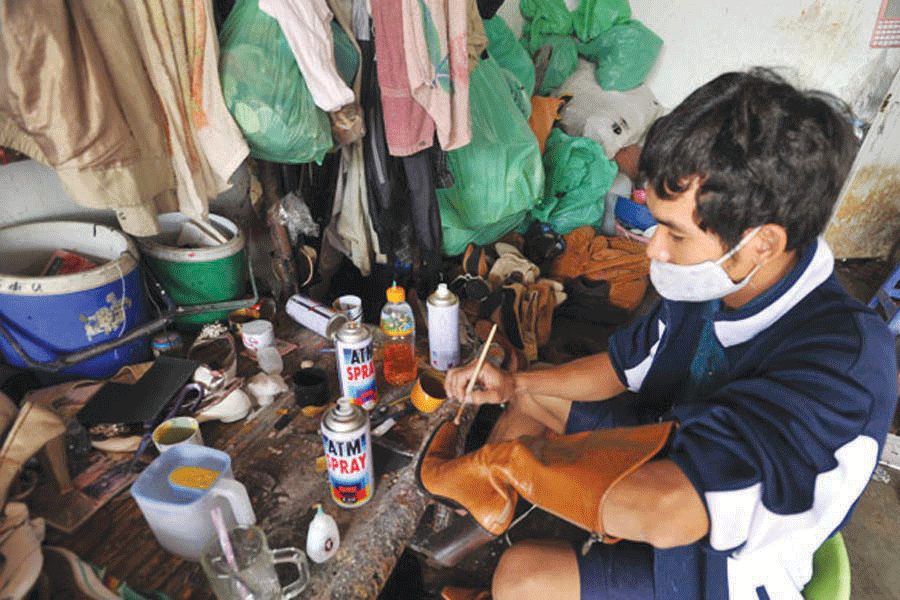  Một người thợ đang đóng giày cho khách. Ảnh: Nguyên Võ