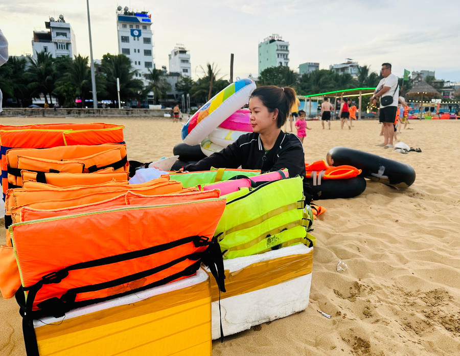Chị Ngô Thị Hồng Nhung sắp xếp lại các loại phao bơi. Ảnh: D.Đ 71.jpg