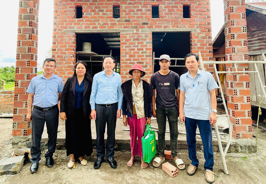 Chủ tịch UBND tỉnh Phạm Anh Tuấn (thứ 3 từ trái sang) tặng quà cho gia đình bà Đinh Thị Chông tại làng Ba Bă, xã Ya Ma. Ảnh: P.D 31.jpg