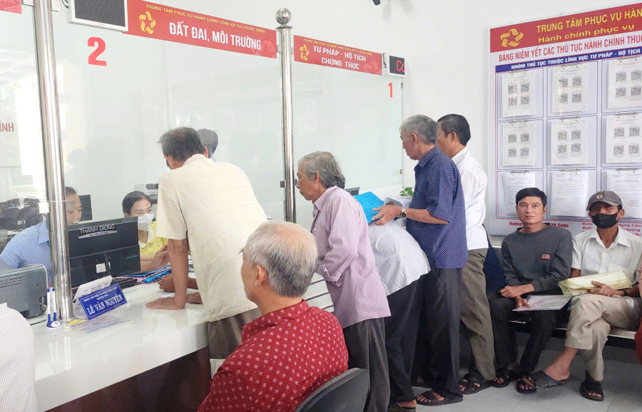 Người dân làm hồ sơ, thủ tục về đất đai tại Trung tâm Phục vụ hành chính công xã Tuy Phước Đông. Ảnh: V.L 91.jpg