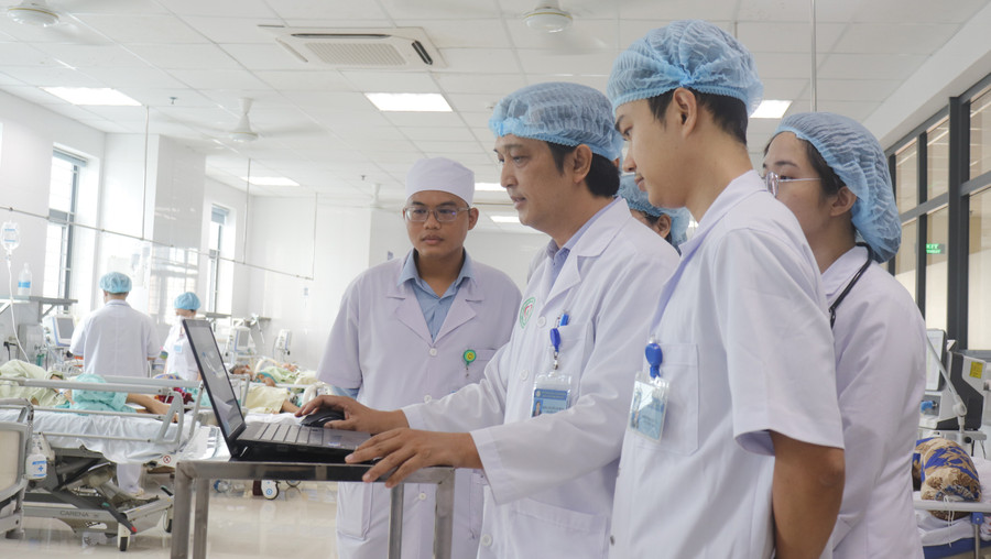 Bác sĩ Nguyễn Văn Trung (người đang thao tác máy vi tính) giao ban từng ca bệnh điều trị với bác sĩ, điều dưỡng. Ảnh: M.H 27-1.jpg
