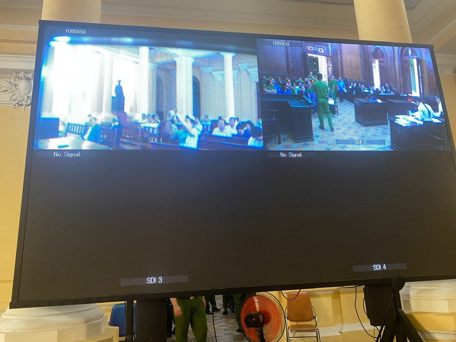 Đầu giờ xét xử, báo chí được tác nghiệp trực tiếp tại phòng xử án, sau 10 phút thì theo dõi phiên xét xử qua màn hình. Ảnh: Tân Châu.