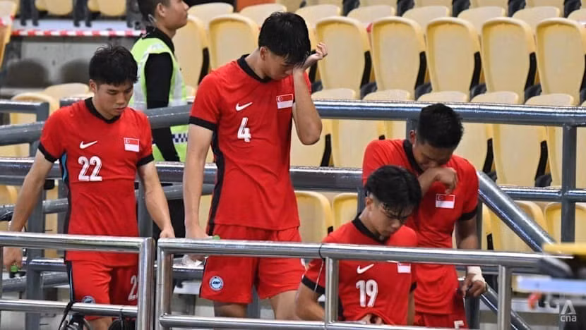 Các cầu thủ U22 Singapore cúi đầu rời đi sau thất bại.