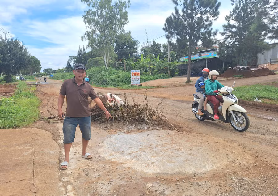 Anh Huỳnh Hoa Thám (tổ dân phố 5, xã Trà Đa) vừa tự bỏ tiền để vá ổ gà trước nhà. Ảnh: Q.T