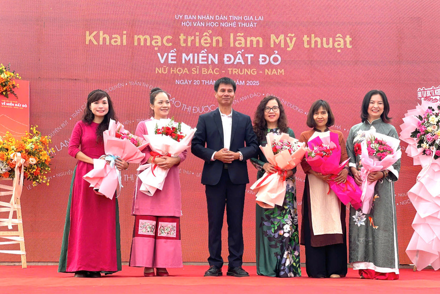 Den förtjänstfulla konstnären Dang Cong Hung - ordförande för Gia Lai litteratur- och konstförening - överlämnade blommor till kvinnliga målare som representerade de norra, centrala och södra regionerna som deltog i utställningen. Foto: Phuong Duyen trung-bay-tranh.jpg