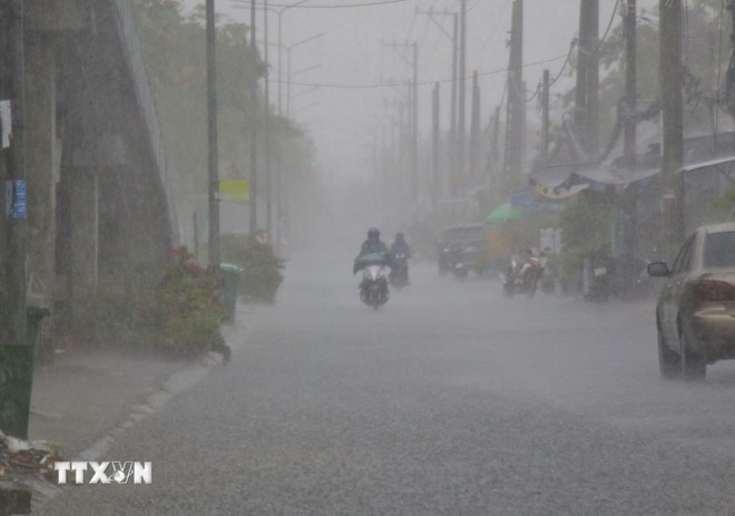 Người dân cần chú ý khi đi ra ngoài trong lúc mưa dông. (Ảnh: Duy Khương/TTXVN) Người dân cần chú ý khi đi ra ngoài trong lúc mưa dông. (Ảnh: Duy Khương/TTXVN)
