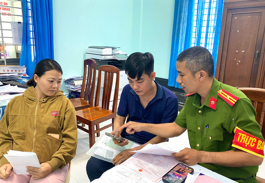 Cán bộ Công an phường An Nhơn Nam hướng dẫn, hỗ trợ người dân thực hiện thủ tục đăng ký thường trú cho con qua ứng dụng VNeID. Ảnh: Nguyễn Chơn dang-ky-thuong-tru.jpg