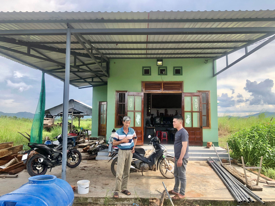 Ông Lê Việt Chiến (bìa trái) bên căn nhà mới xây tại khu tái định cư làng Brel. Ảnh: L.N an-sinh-xa-hoi.jpg