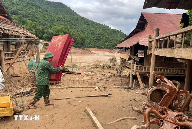 Chiến sỹ Đồn biên phòng Mỹ Lý giúp người dân địa phương khắc phục hậu quả mưa lũ. (Ảnh: TTXVN phát) Chiến sỹ Đồn biên phòng Mỹ Lý giúp người dân địa phương khắc phục hậu quả mưa lũ. (Ảnh: TTXVN phát)