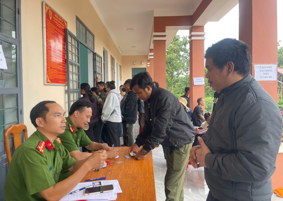 Lực lượng Công an xã Ia Krăi hướng dẫn người dân cài đặt định danh điện tử mức độ 2. Ảnh: Thúy Trinh 92.jpg
