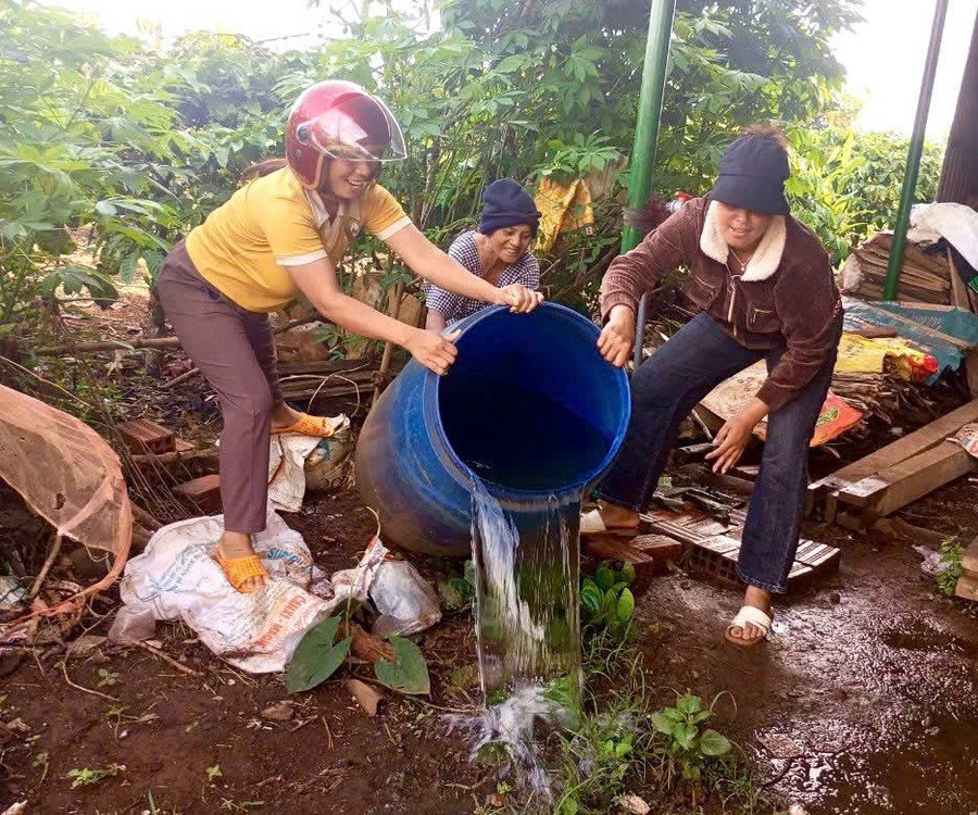 Nhân viên y tế Trạm y tế xã Gào hướng dẫn người dân đổ bỏ dụng cụ đọng nước, không tạo nơi trú ngụ cho lăng quăng, bọ gậy. Ảnh: Đinh Cất 11b.jpg
