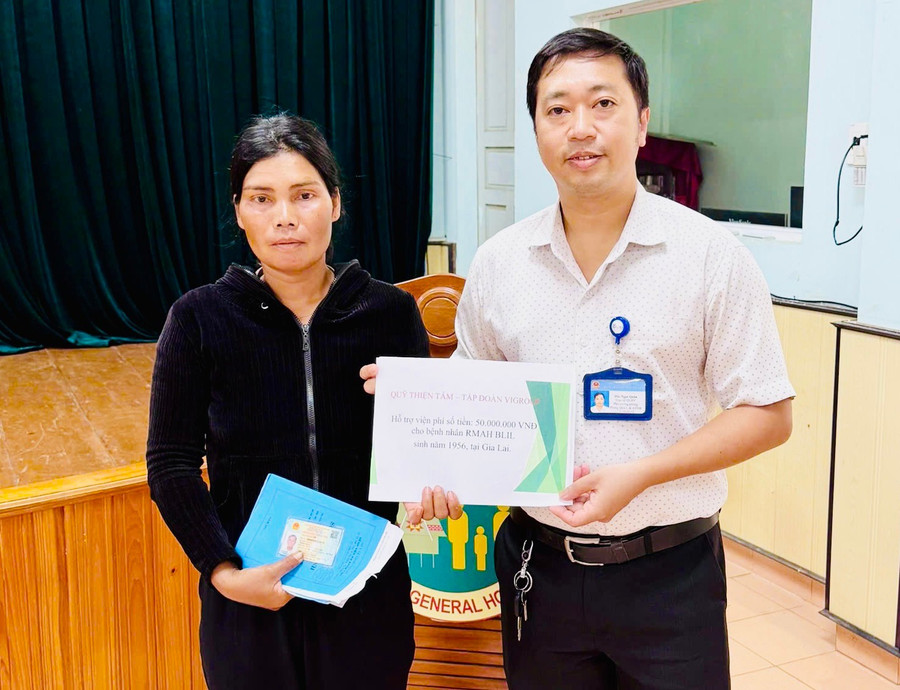 Ông Đào Ngọc Quân-Tổ trưởng Tổ công tác xã hội (Bệnh viện Đa khoa Gia Lai) trao tiền hỗ trợ của Quỹ Thiện Tâm-Tập đoàn Vingroup đến bà Kpuih Uôn (con gái ông Rmah Blil). Ảnh: ĐVCC 10.jpg