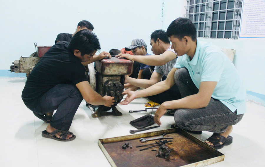 Studenti si do třídy přinášejí rozbité zemědělské stroje, klíče a šroubováky, aby se je učitelé a studenti mohli společně pokusit opravit. Foto: Vu Chi sua-chua-may.jpg