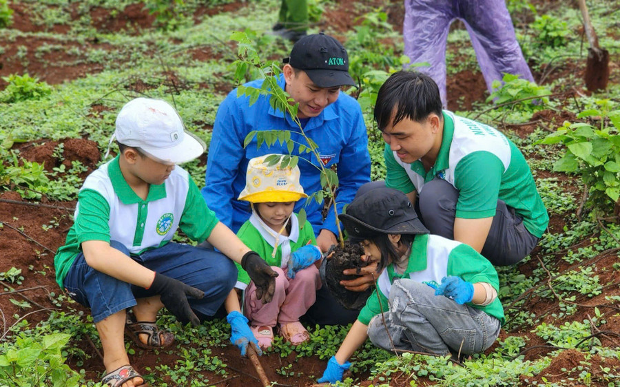 Các thành viên dự án Hành trình xanh hướng dẫn thiếu nhi cách trồng cây xanh. Ảnh: Phan Lài 4.jpg