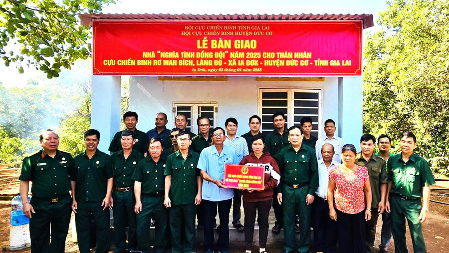 Ông Ngô Công Đoan (hàng đầu, thứ 6 từ trái sang) trao bảng hỗ trợ kinh phí làm nhà Nghĩa tình đồng đội cho thân nhân cựu chiến binh Rơ Mah Bích. Ảnh: Thanh Tịnh 1.jpg