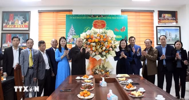 Bà Mai Thị Thúy Nga (đứng bên phải lẵng hoa), Phó Chủ tịch HĐND tỉnh Thái Nguyên cùng đại biểu chúc mừng Ủy ban Đoàn kết công giáo tỉnh Thái Nguyên. (Ảnh: Thu Hằng/TTXVN)