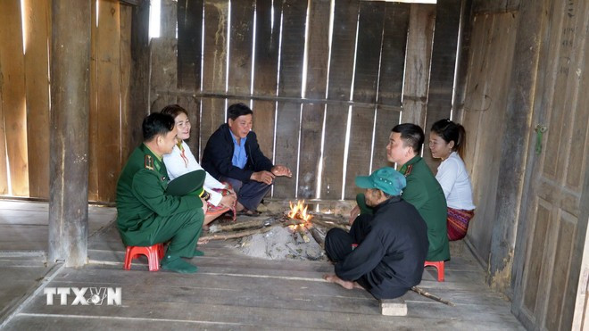 Lực lượng biên phòng và các già làng, trưởng bản đến từng hộ gia đình người Chứt ở bản Rào Tre để tuyên truyền về công tác bầu cử. Ảnh: Hữu Quyết/TTXVN