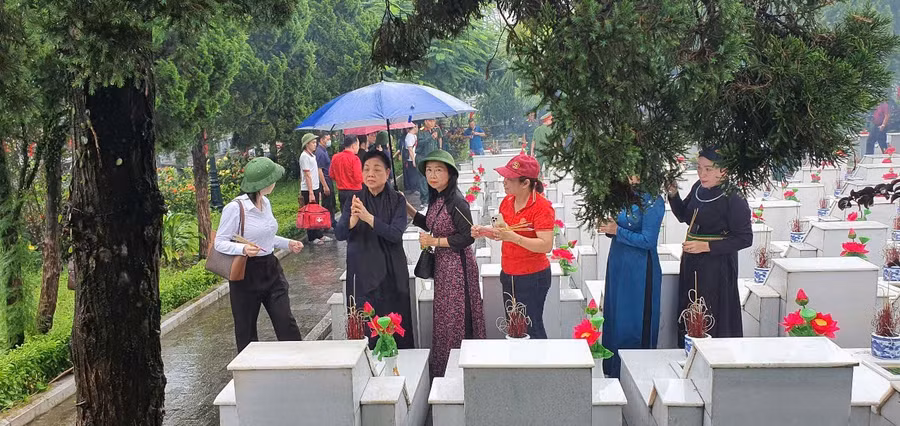 Nguyên Bí thư Trung ương Đảng Hà Thị Khiết bên mộ liệt sỹ Vị Xuyên. Ảnh: Nguyễn Tuấn