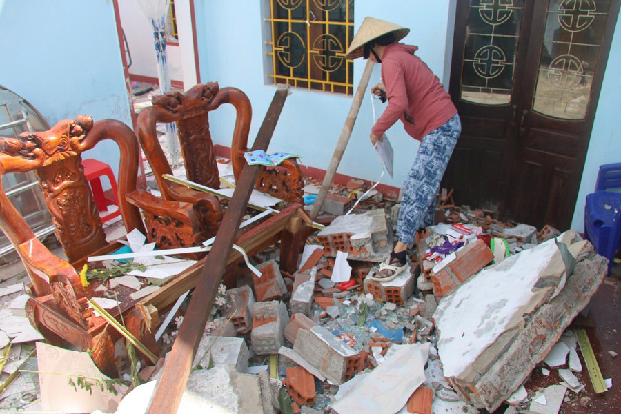 Bà Nguyễn Thị Lan dọn dẹp lại đống đổ nát còn sót lại trong căn nhà của mình. Ảnh: Đức Nhật