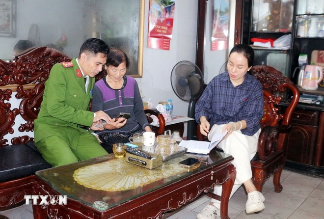 Công an phường Phủ Lý, tỉnh Ninh Bình đến từng hộ tuyên truyền, hướng dẫn người dân tham gia góp ý dự thảo các văn kiện Đại hội XIV của Đảng thông qua ứng dụng VNeID. Ảnh: Nguyễn Chinh/TTXVN