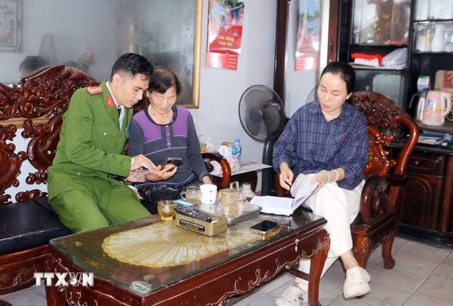 Công an phường Phủ Lý, tỉnh Ninh Bình đến từng hộ tuyên truyền, hướng dẫn người dân tham gia góp ý dự thảo các văn kiện Đại hội XIV của Đảng thông qua ứng dụng VNeID. Ảnh: Nguyễn Chinh/TTXVN