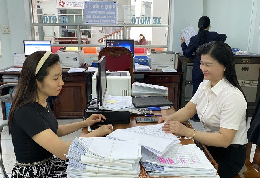 Cán bộ, công chức cơ quan thuế hỗ trợ người dân thực hiện thủ tục hành chính, nâng cao sự hài lòng của người nộp thuế. Ảnh: S.C ho-tro-nguoi-dan.jpg