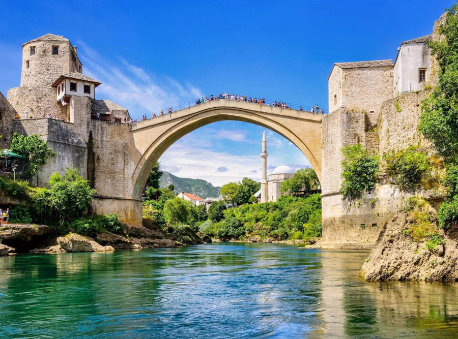 Được xây dựng: Năm 1557-1566 (và 2001-2004). Cây cầu bị phá hủy trong chiến tranh Bosnia năm 1993. Nhưng niềm tự hào của người dân địa phương và nguồn tài trợ quốc tế đã giúp xây dựng lại công trình được yêu mến này từ năm 2001 đến năm 2004, bao gồm cả đá được vớt từ dòng sông bên dưới