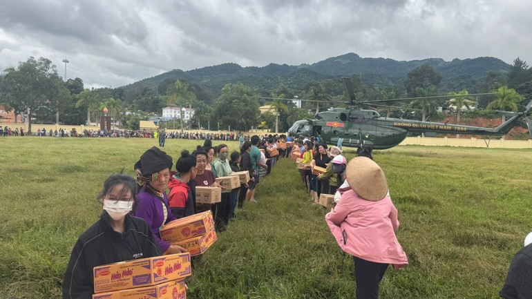 Hàng trăm người dân xã Na Son góp sức vận chuyển hàng cứu trợ.