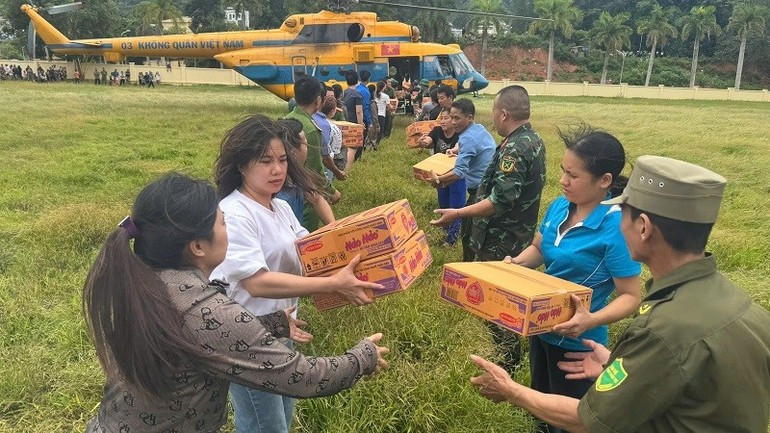 Khẩn trương vận chuyển hàng cứu trợ từ trực thăng tại sân vận động xã Na Son.