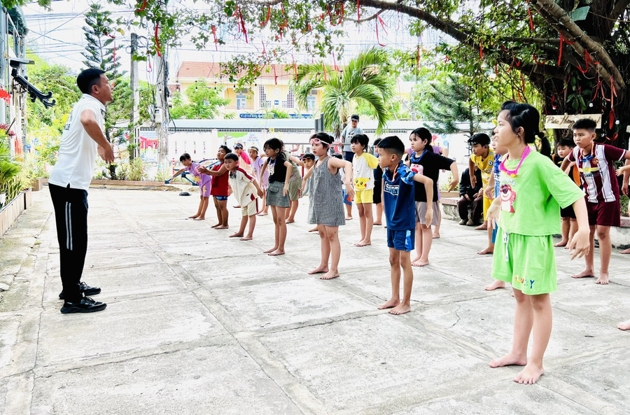 Các em thiếu nhi xã Tuy Phước Bắc khởi động trước khi xuống nước tập bơi. Ảnh: Phan Lài 2-5240.jpg